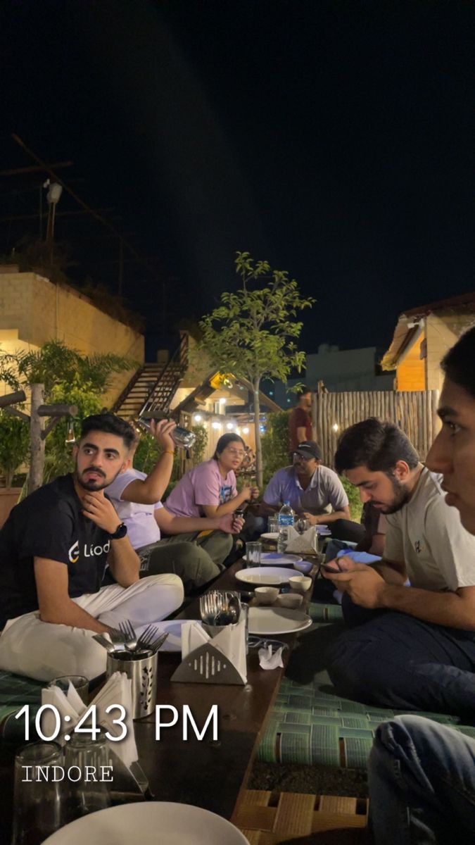 a group of men sitting at a table eating food