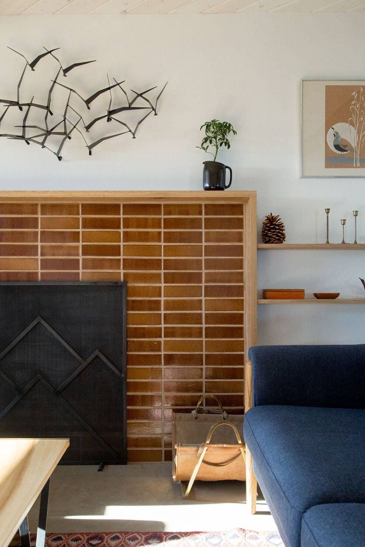 a living room filled with furniture and a fire place next to a wall mounted art piece