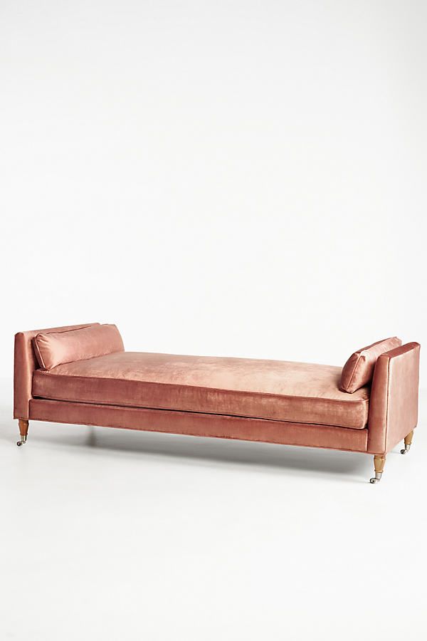 a pink couch sitting on top of a white floor