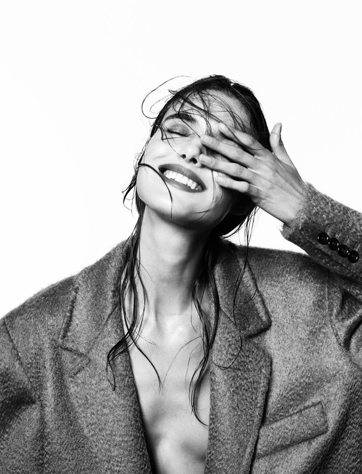 a black and white photo of a woman covering her eyes