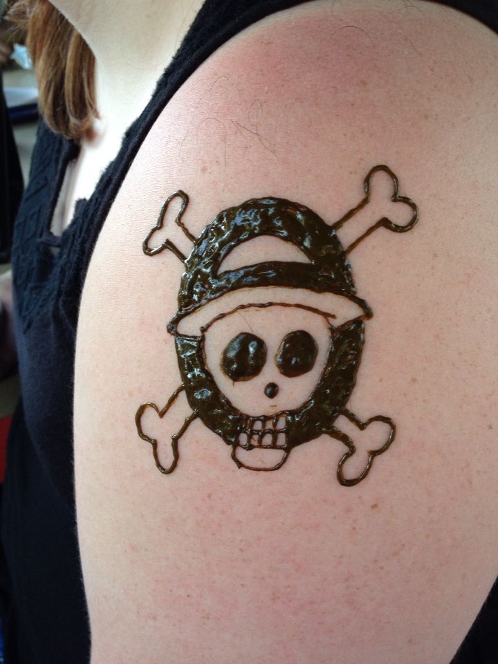 a person with a skull and crossbones tattoo on their arm, wearing a hat