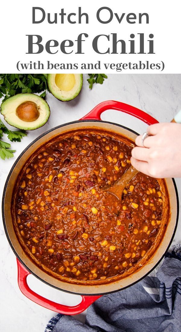 a red pot filled with chili, beans and avocado next to an avocado