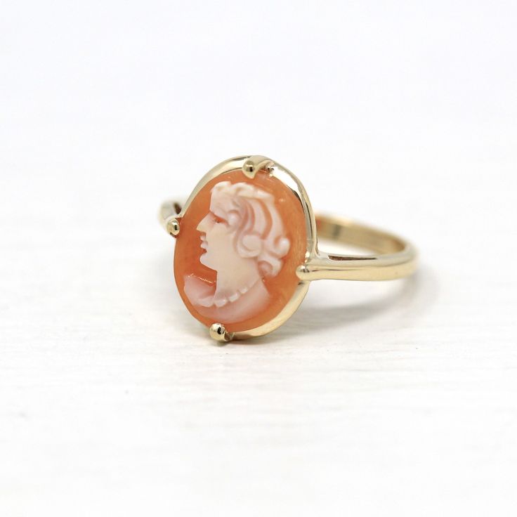 "Lovely vintage circa 1940s era 10k yellow gold cameo ring! This beautiful statement ring features a genuine carved shell cameo, that depicts a beautiful woman's silhouette. The carved shell cameo is securely prong set in the center of the polished, unadorned band. A stunning piece of fine 1940s era cameo jewelry! *Sale - price reduced from $450 USD to $440 USD.  ERA - Circa 1940s - Retro  METAL / MATERIAL - 10k yellow gold, genuine carved shell cameo. MARKINGS / HISTORY - Inside of shank is marked \"10k\" with a shield shape. CONDITION - Good vintage condition. Ring has been refurbished, polished, and cleaned by our jeweler. Prongs have all been re-tipped by our jeweler. Very little age remains to metal. Genuine shell is secure and is in nice shape. An amazing vintage cameo ring! SIZE / M Vintage 14k Stamped Jewelry For Formal Occasions, Retro Yellow Gold Rings Stamped 14k, Vintage Cameo Jewelry For Wedding, Vintage Ring Jewelry For Vintage Events, Collectible Classic Jewelry With Vintage Charm, Vintage Gold Cameo Ring, Cameo 14k Gold Rings For Collectors, Classic Yellow Gold Cameo Jewelry, Vintage 14k Gold Cameo Rings