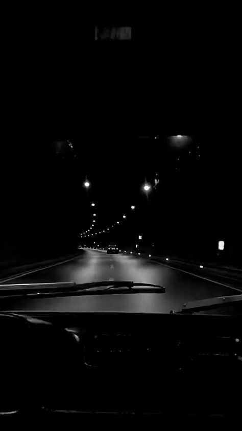 a car driving down a dark street at night