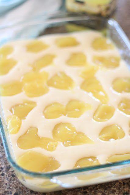 a casserole dish filled with lemon custard and white icing in a glass baking dish