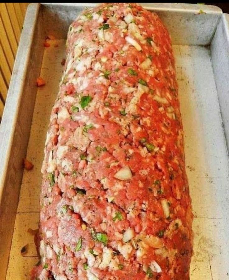 a large meatloaf is sitting on a pan and ready to be cooked in the oven