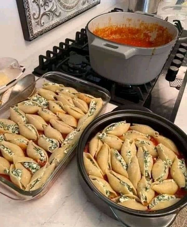 two pans filled with food sitting on top of a counter next to an oven