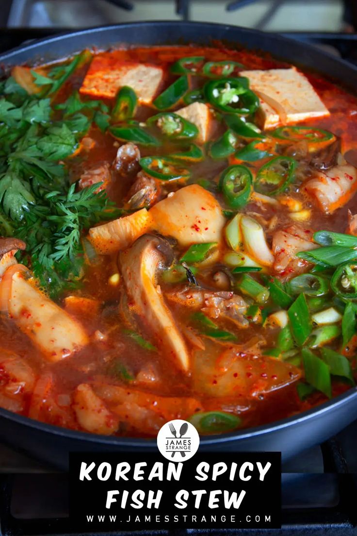 korean spicy fish stew in a pan on the stove with green vegetables and tofu