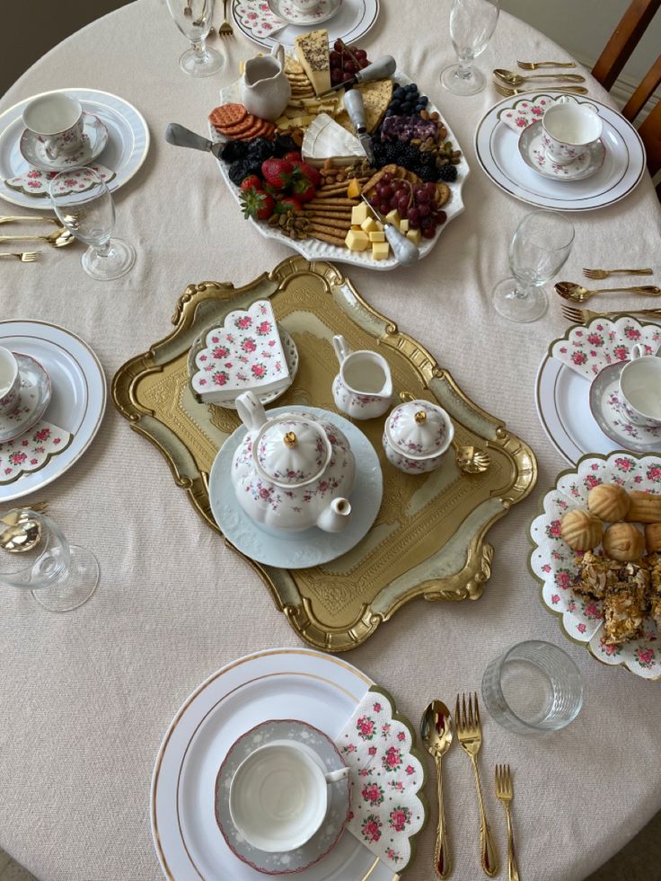 the table is set with dishes, silverware and other things to eat on it