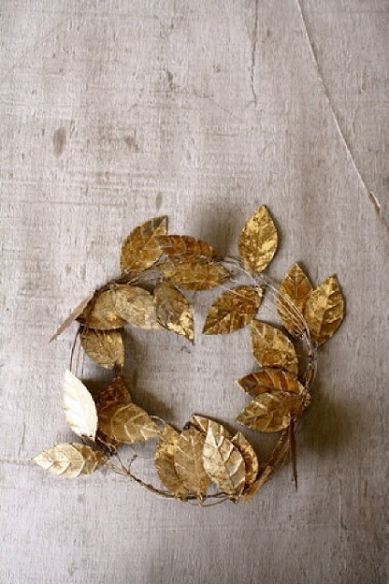 a wreath made out of gold leaves on a table