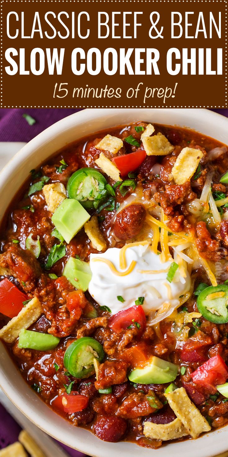 a bowl filled with chili, cheese and avocado next to tortilla chips