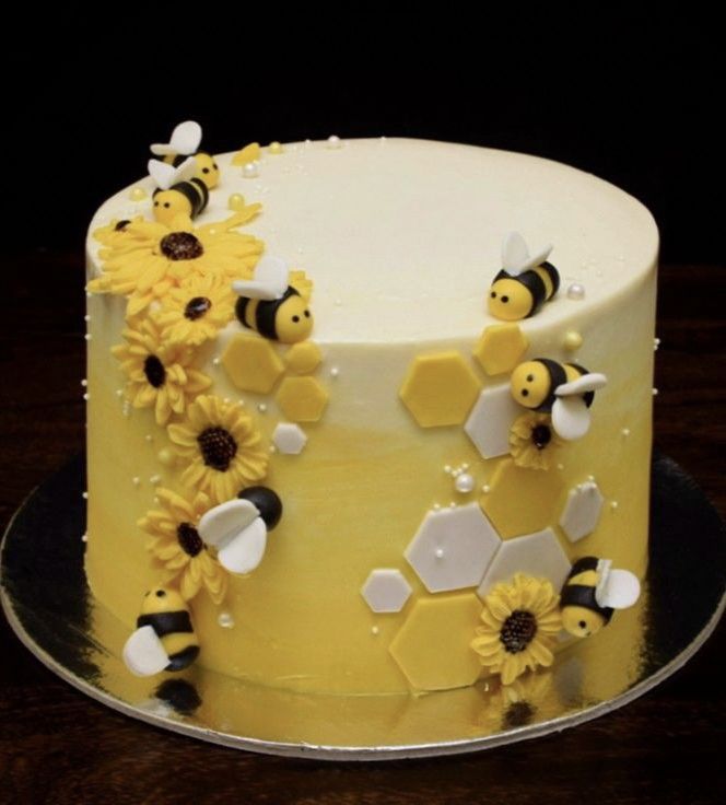 a yellow cake with bees and sunflowers on it