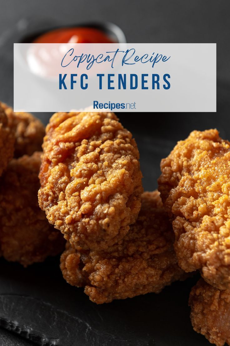 fried chicken tenders on a black plate with ketchup and dipping sauce in the background