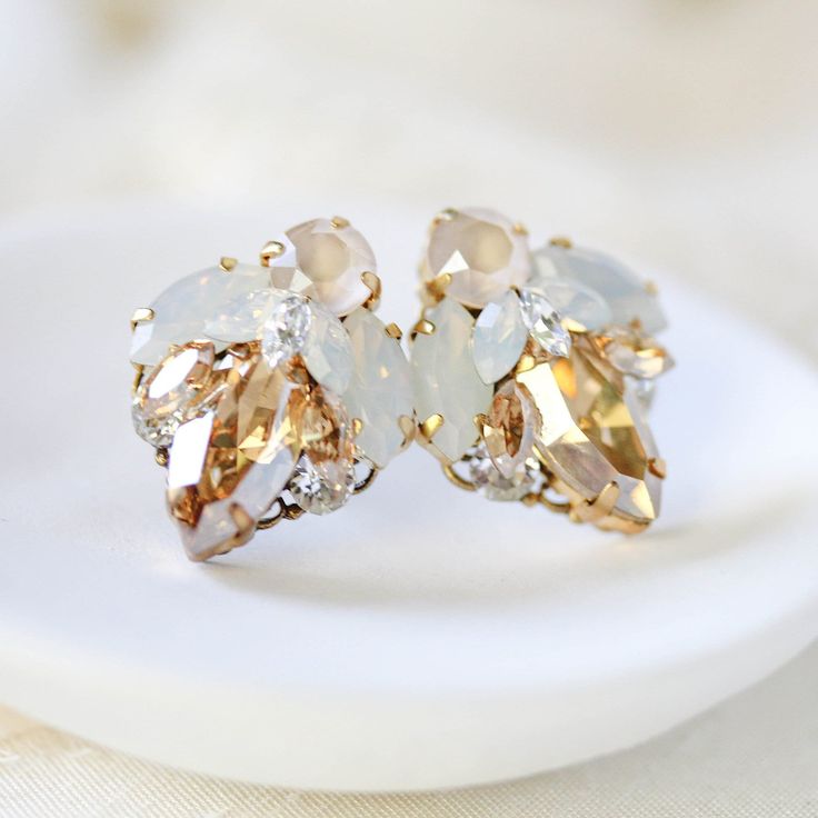 These delicate antique gold bridal stud earrings are layered with a variety of Premium European Crystals to create an elegant design perfect for any bridal look!  - Handcrafted with Premium European Crystals - Each stone is set by hand in my studio - Golden shadow, white opal, ivory cream and clear Premium European Crystals - Antique gold finish - Earrings measure 7/8 inch x 3/4 inch - Handcrafted in the US. - Nickel free and hypoallergenic - READY TO SHIP AS PICTURED This is an original design Dainty Gold Bridal Earrings For Wedding, Gold Crystal Earrings With Sparkling Stones For Wedding, Exquisite Gold Earrings For Wedding, Delicate Gold Cluster Earrings For Anniversary, Dainty Sparkling Stones Earrings For Wedding, Dainty Wedding Earrings With Sparkling Stones, Elegant Gold Cluster Earrings For Wedding, Dainty Gold Earrings For Wedding, Gold Earrings With Sparkling Stones For Wedding