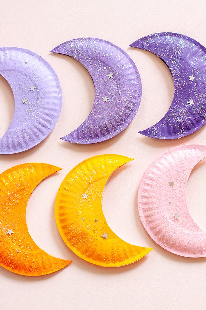 five paper plates with different moon designs on them, all painted in purple and yellow