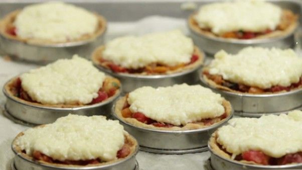 many small pies are sitting in tin pans