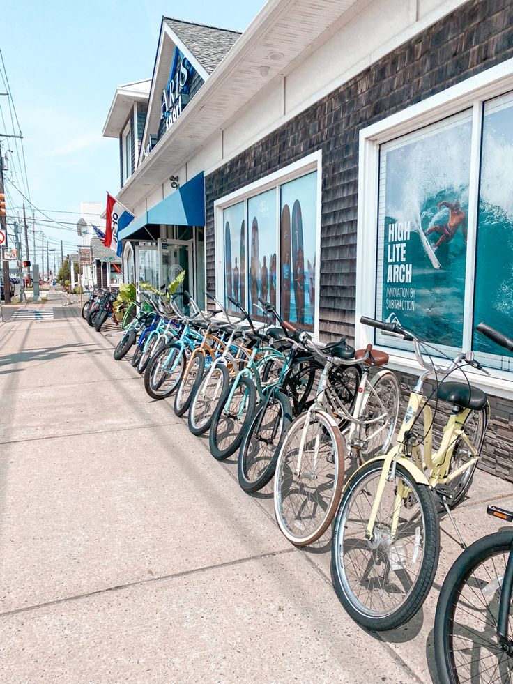 a row of bikes parked next to each other in front of a building with windows