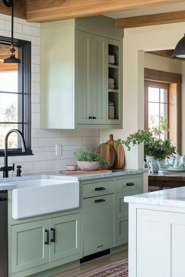 a kitchen with green cabinetry and white counter tops, an island style sink and black faucet