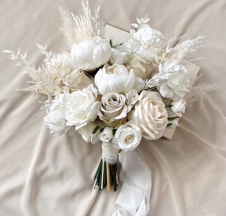 a bouquet of white flowers on a bed