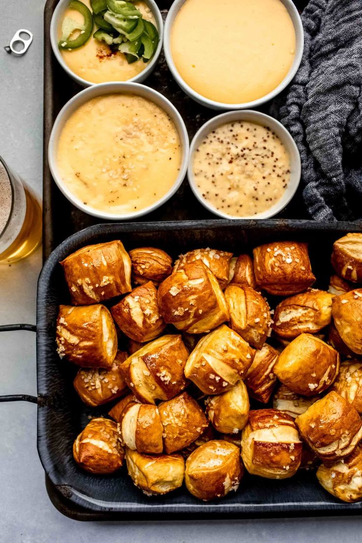 a tray filled with different types of food next to cups and sauces on a table