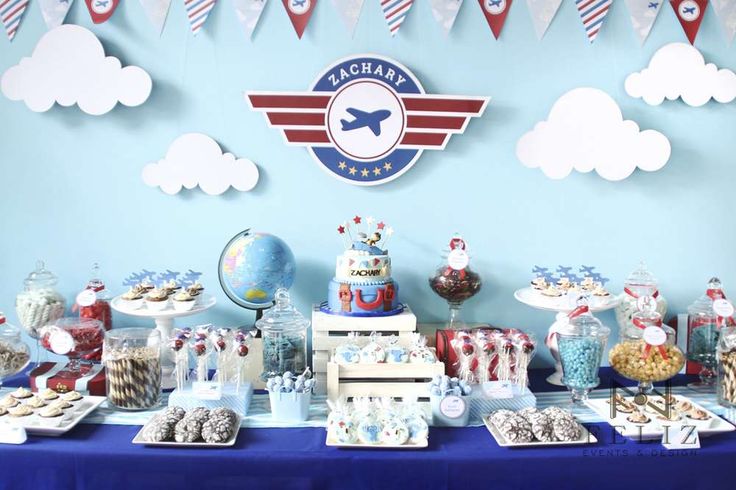 an airplane themed birthday party with desserts and candies on a blue table cloth