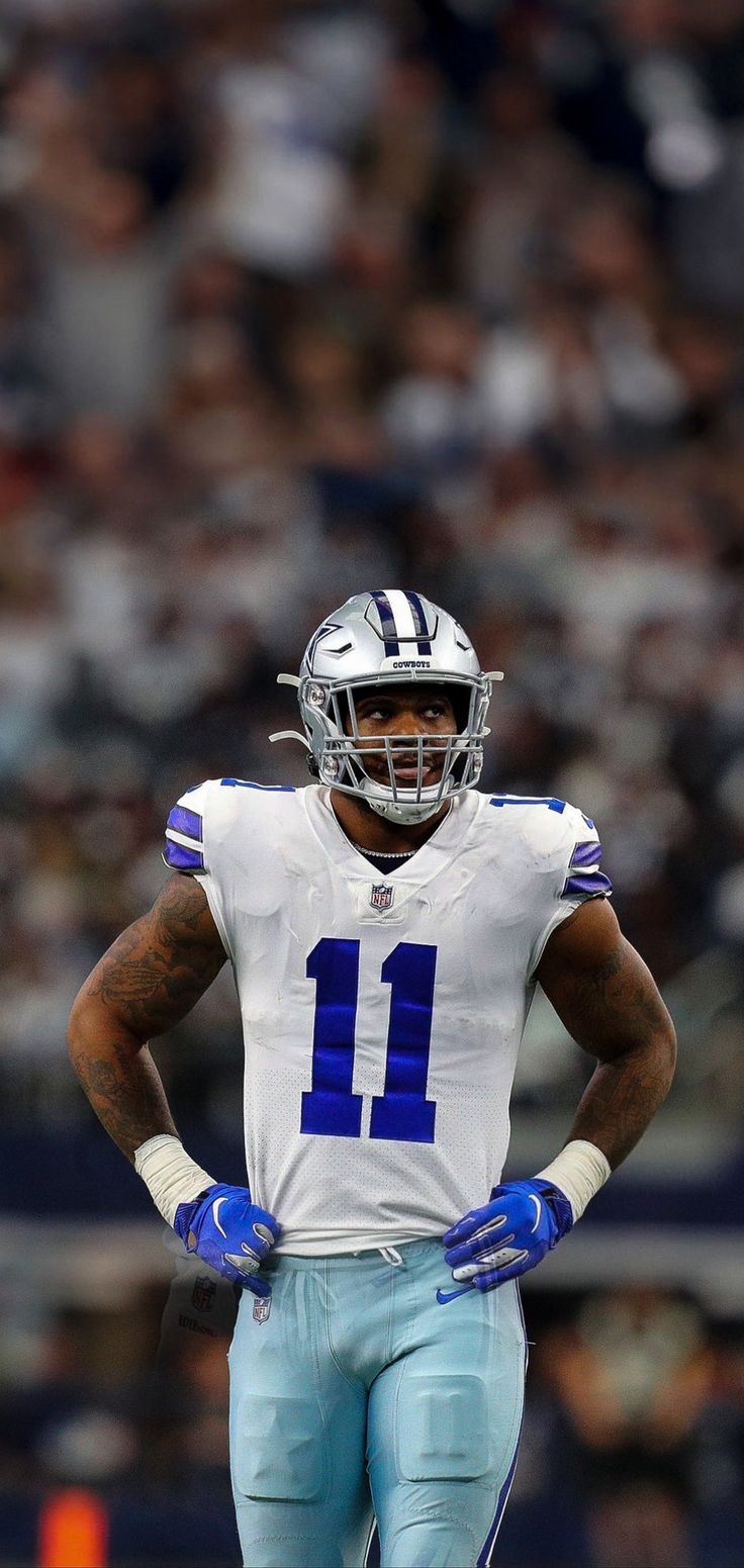 a close up of a football player with his hands on his hips while standing in front of an audience