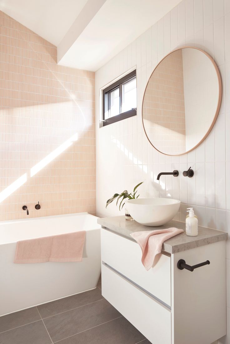 a bathroom with a sink, mirror and bathtub next to a window on the wall