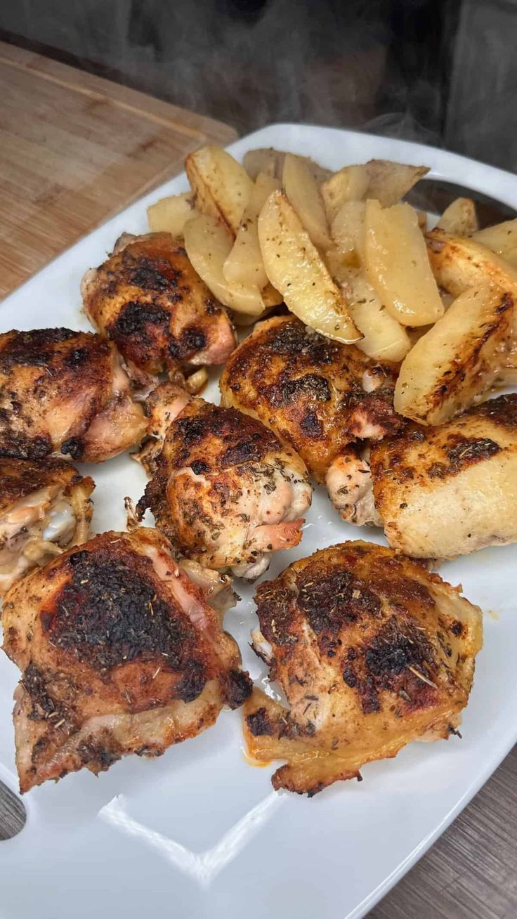 some chicken and potatoes on a white plate