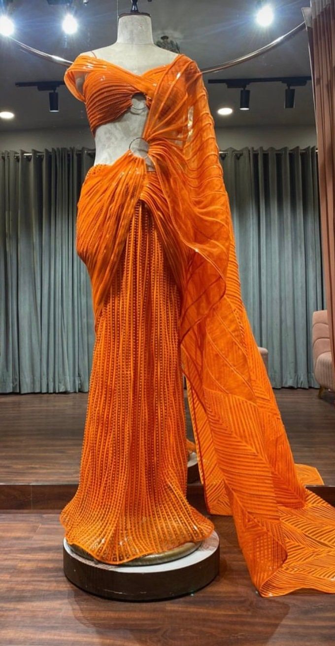 Amazing indowestern saree made on organza fabric with crepe butter lining embellished with metallic lines and Pearl work Orange Georgette Sharara With Traditional Drape, Georgette Sharara With Cutdana In Orange, Orange Georgette Sharara With Cutdana, Georgette Pre-draped Saree With Cutdana, Chanderi Pre-draped Saree With Zari Work For Formal Events, Evening Pre-draped Saree In Georgette With Cutdana, Evening Pre-draped Cutdana Georgette Saree, Formal Pre-draped Saree With Sheer Dupatta For Festivals, Formal Festive Pre-draped Saree With Sheer Dupatta