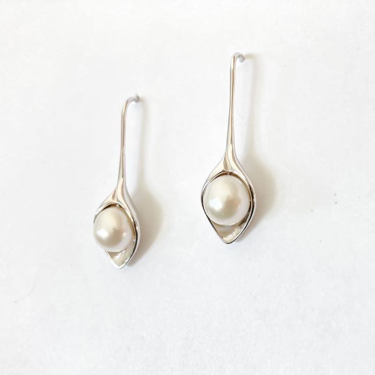 Featuring a classic and sophisticated look, the Lily pearl earrings are a popular choice among customers. These precious pieces are crafted with lustrous freshwater pearls and set in a singularly shaped rhodium setting. Materials: Freshwater pearl. Rhodium setting. Drop Length: 1" Make it a set with our matching Lily necklace. Original copyright design