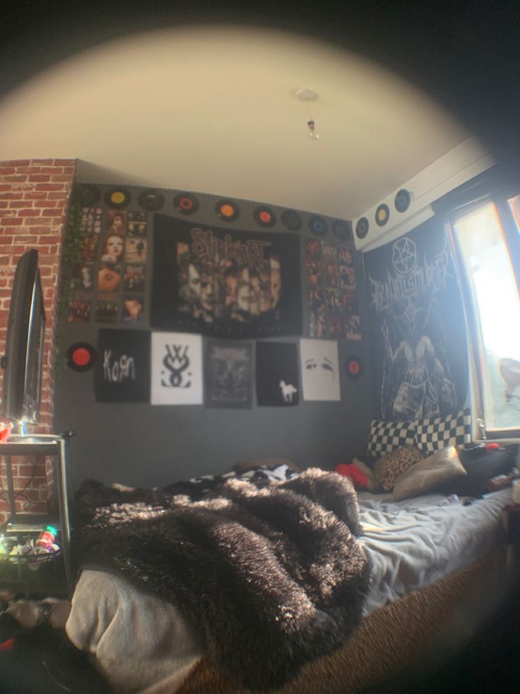 a bed room with a neatly made bed and lots of pictures on the wall above it