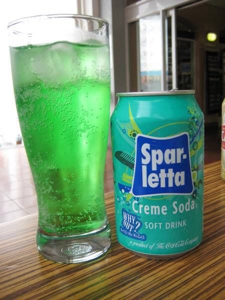 a can of soda next to a glass on a table