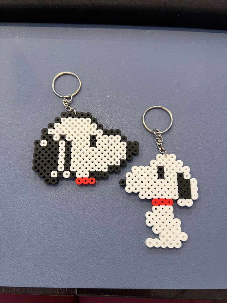 two cross stitch keychains that look like cartoon characters