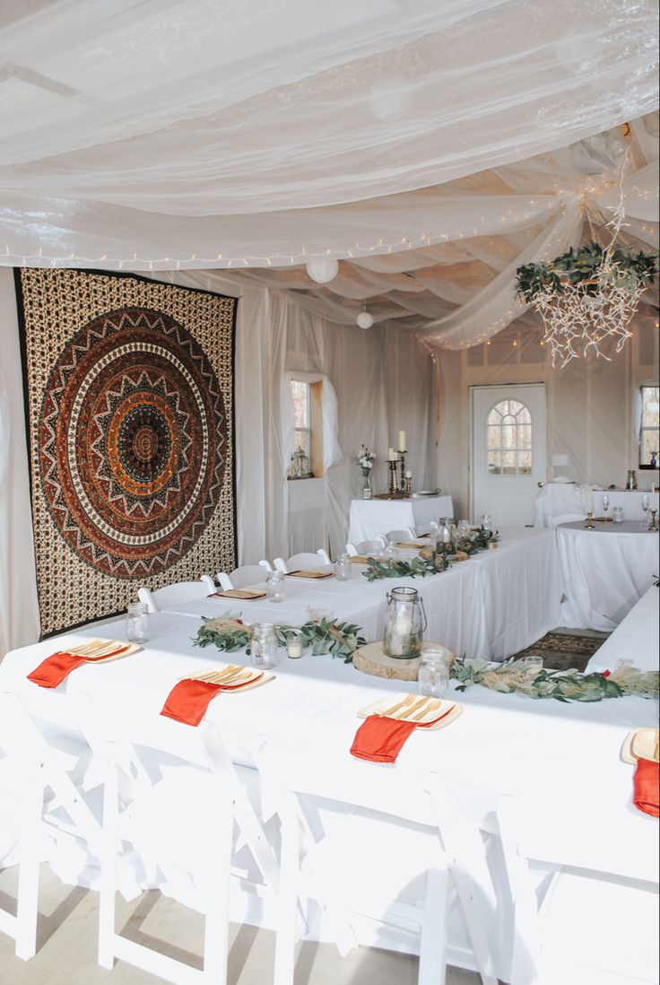 a banquet table set up with white linens and red place mats