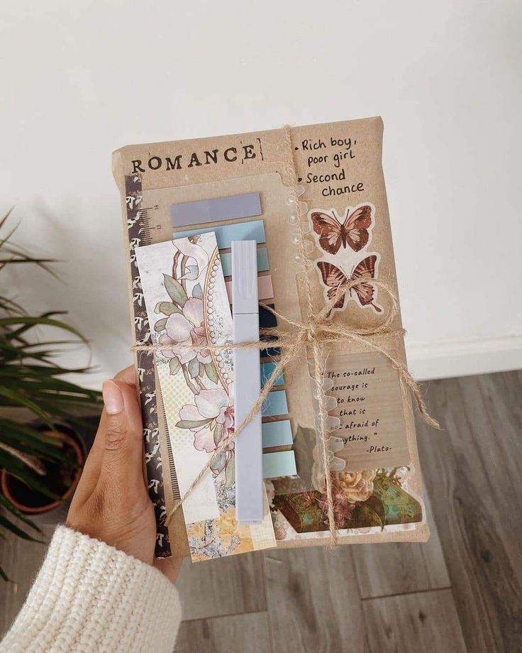 a person holding up an old book with butterflies on it