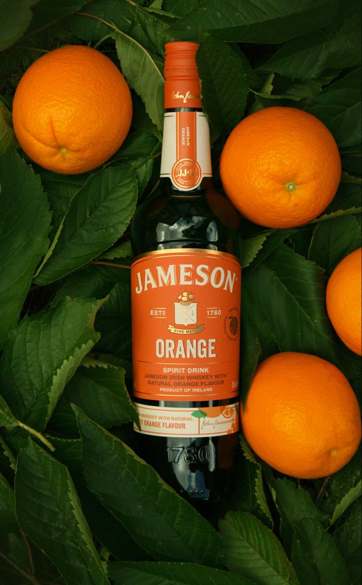 an orange bottle surrounded by green leaves