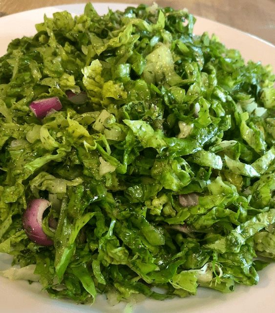 a white plate topped with lettuce and onions