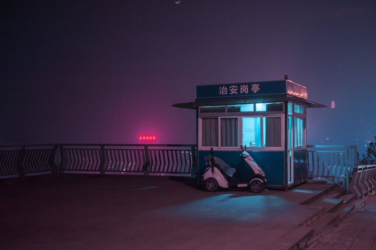 a small bus stop sitting on the side of a road next to a body of water