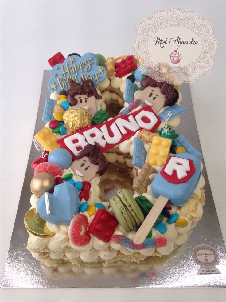 a birthday cake with the number 5 on it's top and various candies