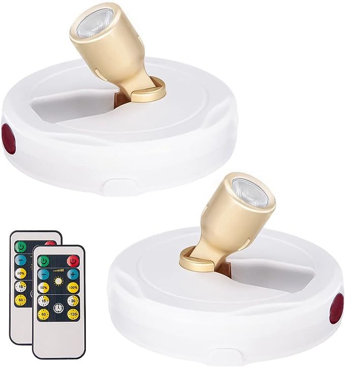 two white speakers with remotes on top of them