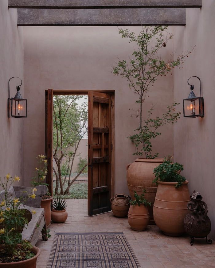 an instagram page with pots and plants on the front porch, in spanish style