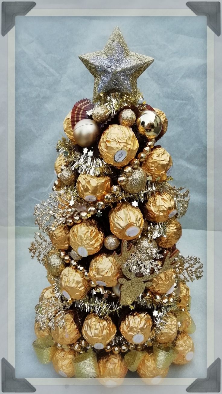 a christmas tree made out of chocolates and gold ornaments with a star on top