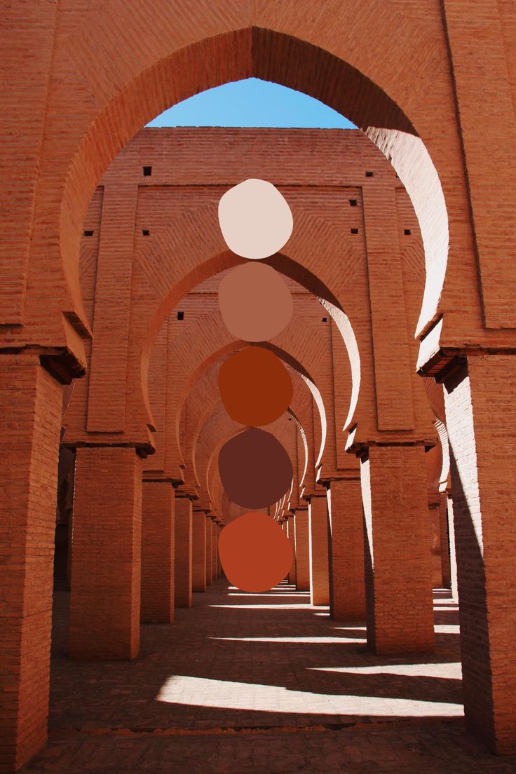 an arch in the middle of a brick building with multiple circles on it's sides