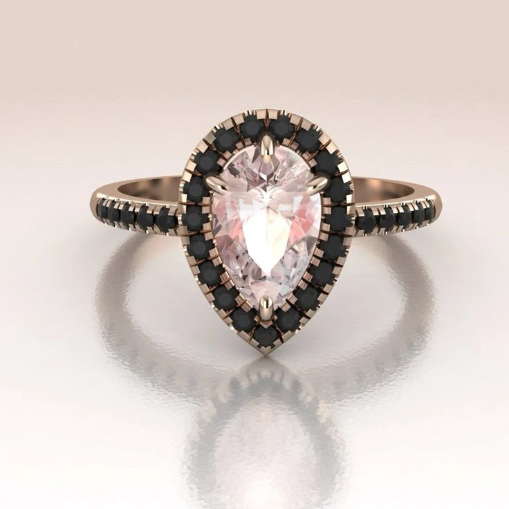 a pink and black diamond ring on a white surface with reflection in the middle,