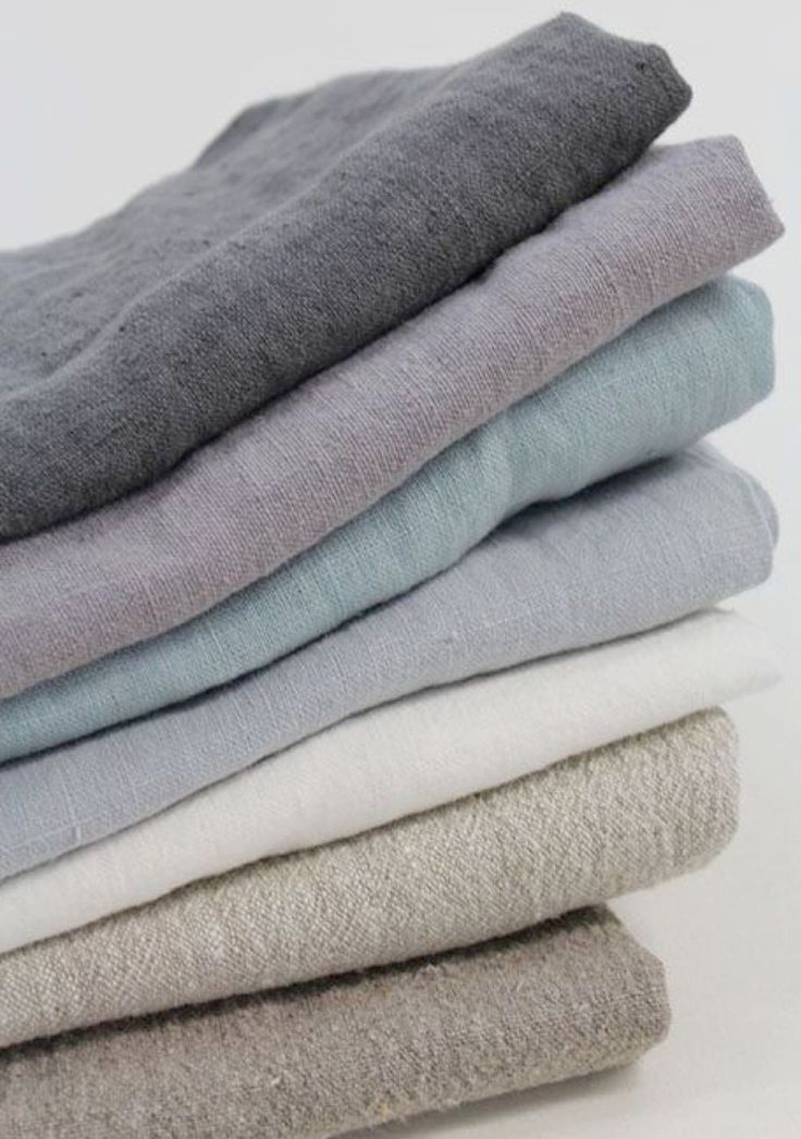 a stack of folded towels sitting on top of each other in different colors and sizes