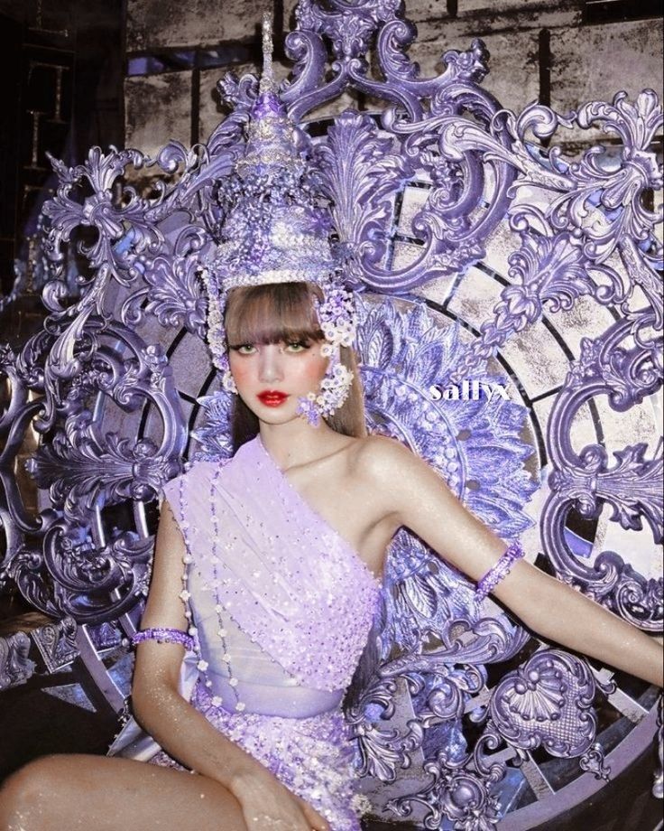 a woman sitting on top of a chair wearing a tiara and dress with beads