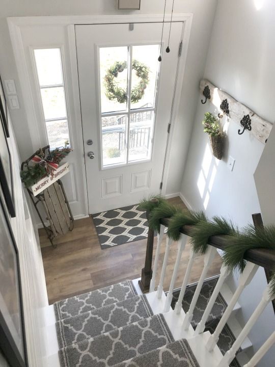 an overhead view of a staircase with christmas wreaths on the banister and door