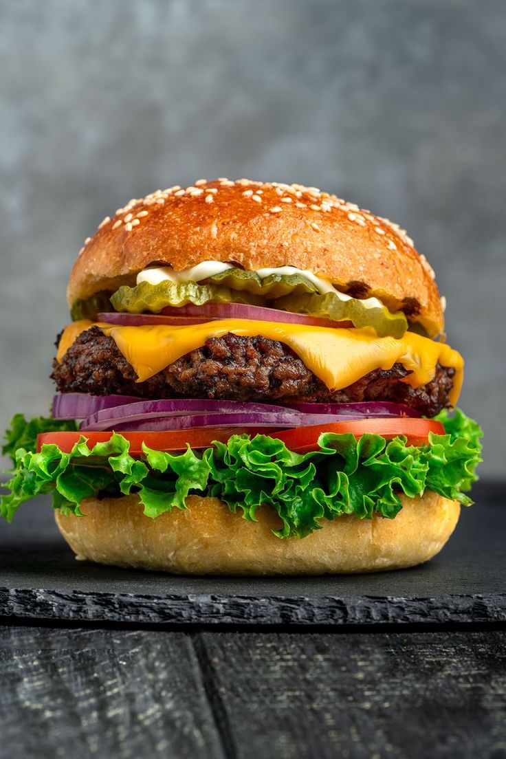 a cheeseburger with lettuce, onions and pickles