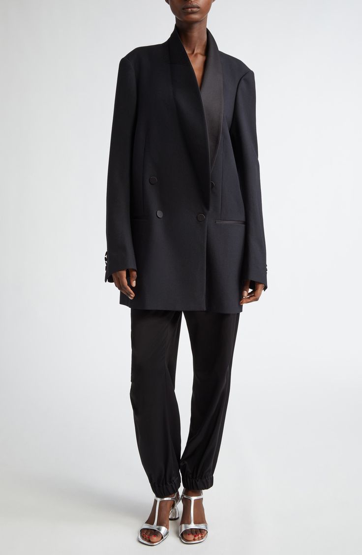 Van Noten's unique take on the tuxedo jacket means an oversized cut that draws attention to what makes it the pinnacle of formalwear, such as the balance struck between matte and sheen via satin covering the buttons, pocket openings and smoothly curved lapels. This style was represented in the Belgian designer's fall '24 runway show. 36" length (size Small) Double-breasted button closure Shawl collar Four-button cuffs Chest welt pocket; front welt pockets Lined 82% wool, 10% silk, 8% polyester D Designer Evening Blazer With Double-breasted Buttons, Black Double-breasted Evening Suit, Black Structured Boning Outerwear For Evening, Evening Tuxedo Suit With Double-breasted Button Fastening, Evening Tuxedo Suit With Double-breasted Button, Evening Tuxedo With Double Button Closure And Long Sleeves, Evening Tuxedo With Double Button And Long Sleeve, Evening Double-breasted Tuxedo Suit, Modern Evening Suits With Suit Collar