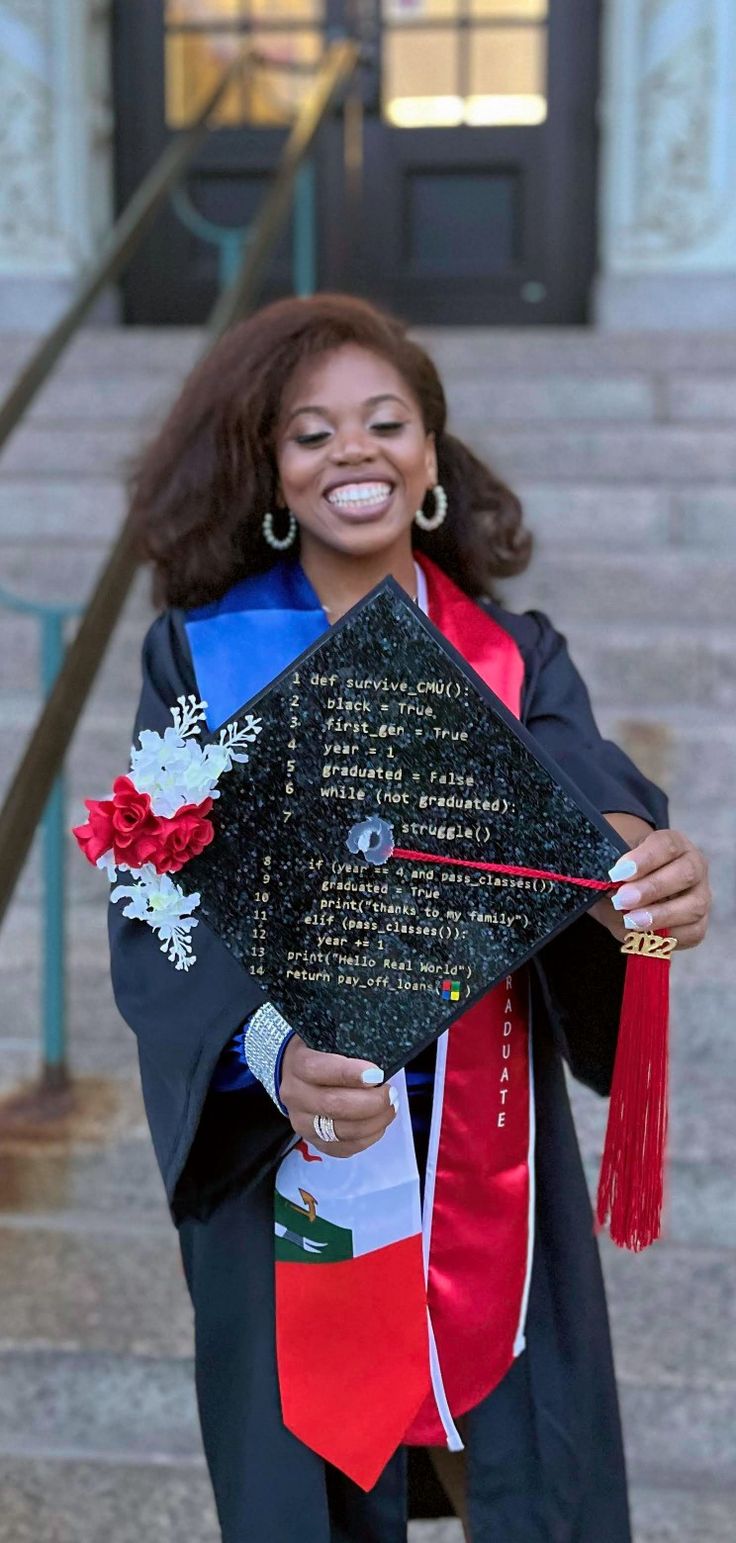 a woman in graduation gown holding up her cap and tasseled scarf with writing on it